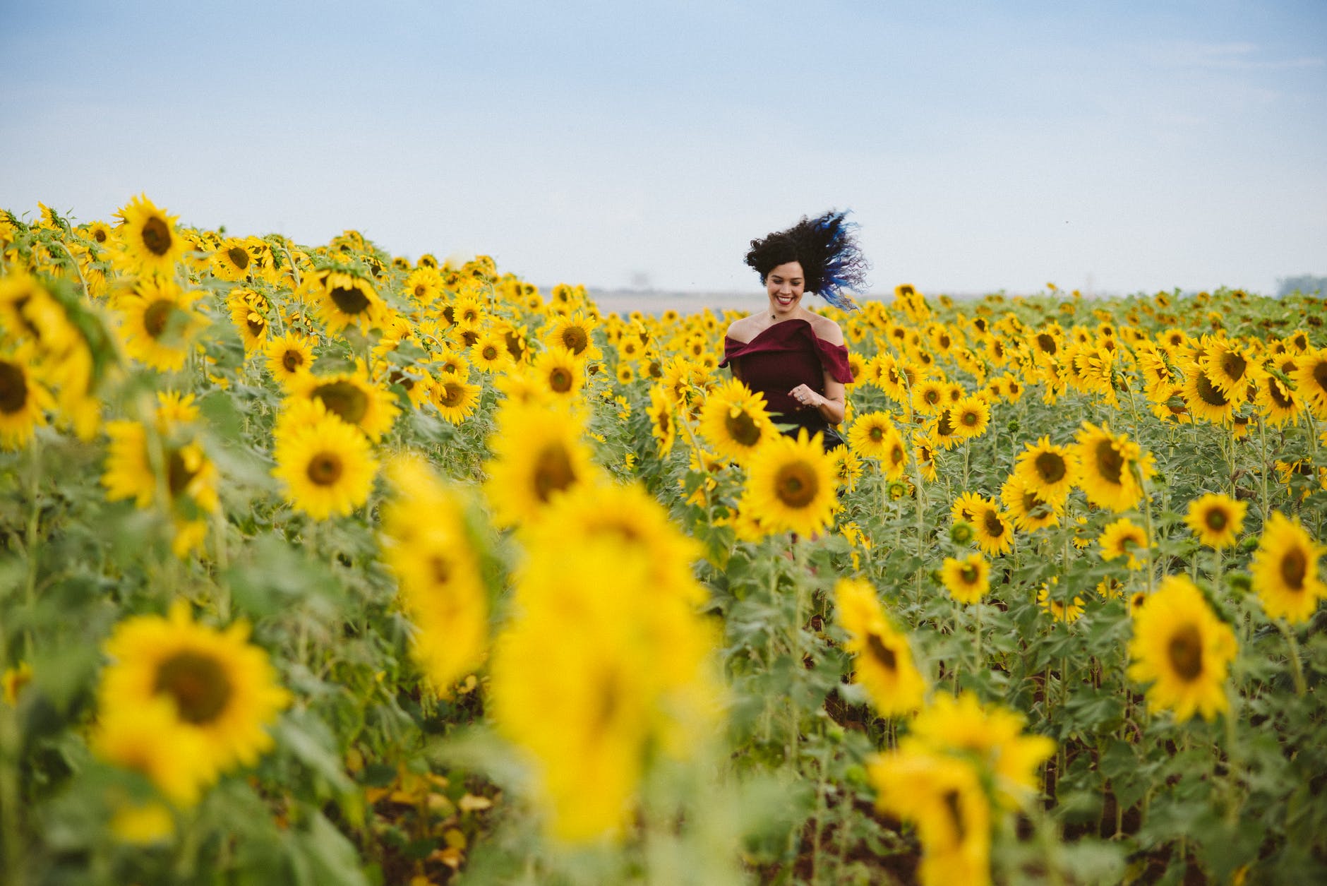 photo of woman smiling on sunflower field